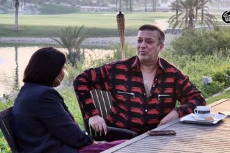 Mahesh Tourani seated in his Emirates Hills mansion, surrounded by luxury and greenery.